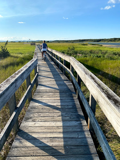 Weekend in The Hamptons: Girl riding bike near Meadow Lane Boardwalk in Southampton, New York