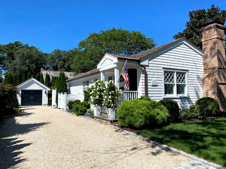 Weekend in The Hamptons: White house with flowers and American flag in East Hampton, New York