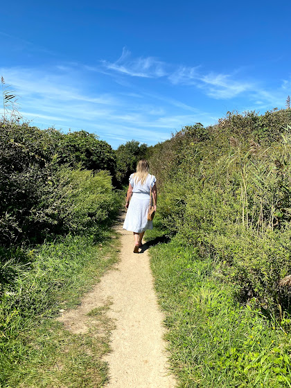 Weekend in The Hamptons: Girl walking on sandy path through bushes