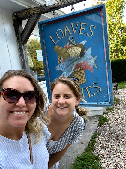 Weekend in The Hamptons: Two girls in front of Loaves and Fishes sign in East Hampton, New York