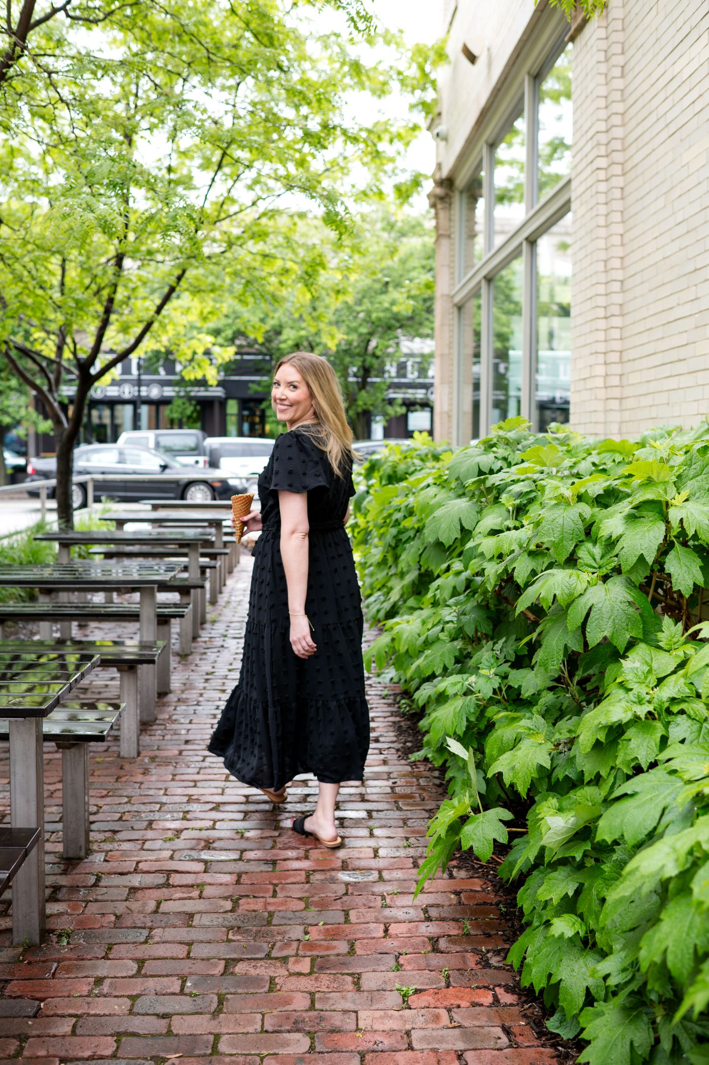 Darcy Warden walking outdoors with an ice cream cone during a summer branding session